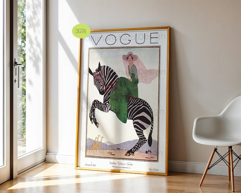 May include: A framed vintage Vogue magazine cover print featuring an illustration of a person in a green dress and wide-brimmed hat riding a zebra. The artwork includes two giraffes in the background, the text VOGUE, and the date January 15 1926.