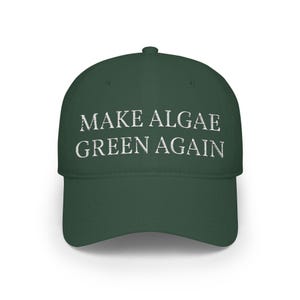 May include: A dark forest green baseball cap featuring the embroidered white text "MAKE ALGAE GREEN AGAIN" centered on the front panel. The cap has a structured crown, a curved brim, and a button at the top, showcasing a clean and simple design.