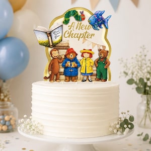 May include: A white frosted cake topped with a decorative sign featuring the text A New Chapter, a green caterpillar, a blue fish, an open book, and illustrations of Curious George, Paddington Bear, Madeline, and a brown bear standing by books.