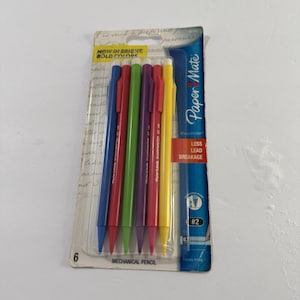 May include: A pack of six Paper Mate SharpWriter mechanical pencils in blue, red, green, purple, pink, and yellow. The packaging features the text Paper Mate, SharpWriter, #2, and Less Lead Breakage, with a clear plastic front display.