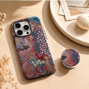 May include: A smartphone case and a matching circular phone grip featuring a complex, multi-colored pattern of red, blue, and gold abstract shapes, swirls, and star-like motifs. The case has a cutout for a triple-lens camera system on the back.