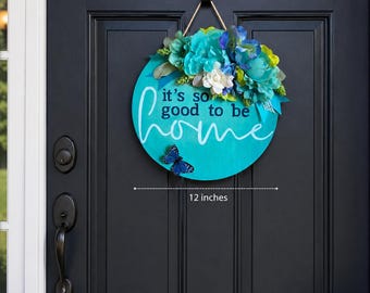 Colgante de puerta redondo de madera de 30 cm con diseño floral "Es tan bueno estar en casa"
