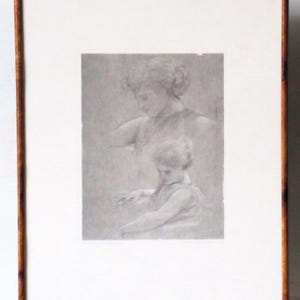 May include: A framed pencil sketch of a woman and child. The artwork is in grayscale, with the woman depicted above the child. The frame is a dark wood with a gold trim.