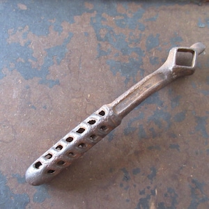 Elevador de manija de estufa antiguo de hierro fundido, rústico, herramienta de recuperación para casas de campo.