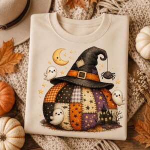 May include: A beige crewneck sweatshirt featuring a graphic of a patchwork pumpkin wearing a black witch hat. The design includes three small white ghosts, a yellow crescent moon, a hanging spider, and a dark silhouette of a haunted house.