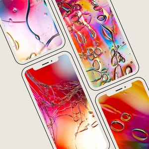 May include: A collection of five smartphones displayed at an angle, each featuring a vibrant, abstract digital wallpaper with swirling gradients of red, orange, yellow, and pink, accented by translucent, bubble-like circular patterns.