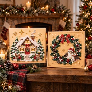 May include: Two square diamond painting canvases featuring Christmas themes. One canvas displays a snow-covered cottage with pine trees and stars. The second canvas shows a festive wreath with two birds wearing hats, decorated with pinecones and berries.