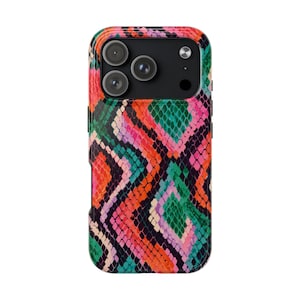 May include: A smartphone case featuring a vibrant, multi-coloured snakeskin pattern in shades of bright orange, emerald green, magenta, and black. The design consists of repeating diamond-shaped scales covering the back of the protective cover.