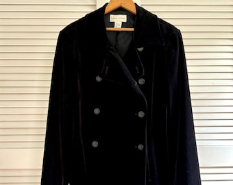 May include: A black double-breasted jacket made of a soft velvet-like fabric. The jacket features a wide collar, long sleeves, and six dark buttons arranged in two vertical rows on the front. A label inside the neck reads Casual Corner.