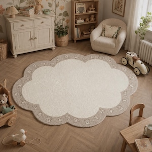 May include: A cloud-shaped area rug featuring a cream-colored center and a wide, light brown border. The border is decorated with a repeating pattern of small, line-drawn illustrations of teddy bears, birds, and other woodland creatures.