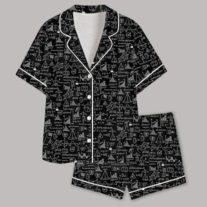 May include: A black short-sleeve button-down shirt and matching shorts set featuring a white print of various mathematical formulas, geometric shapes, and graphs. The garment includes white piping along the collar, front placket, and cuffs.