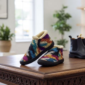 Può includere: Un paio di stivaletti con un vivace motivo intrecciato multicolore nelle tonalità del blu, arancione, viola e giallo. Gli stivaletti presentano una spessa suola in gomma nera e una fodera in pelliccia sintetica color crema sul bordo.