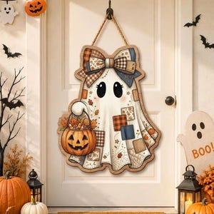 May include: A wooden door hanger shaped like a ghost with a large plaid bow, holding a jack-o'-lantern bucket filled with candy. The ghost features a patchwork design with various patterns and colors, suspended by a thick rope from a metal hook.