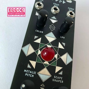 Op de afbeelding: Een zwarte Eurorack-module met de tekst "sound-scaper" en "eurorack" gedrukt op de bovenkant. De module heeft vier knoppen, een rode knop en de tekst "TRIG. IN", "DRUM OUT", "AUDIO OUT", "COLOR", "LFO", "METALIC PITCH" en "SCAPE SHAPER" gedrukt op de voorkant.