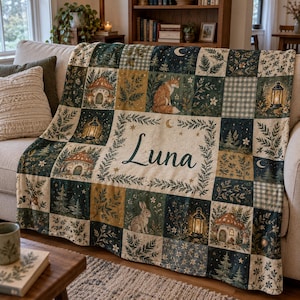 May include: A patchwork throw blanket featuring a forest theme with illustrations of foxes, rabbits, mushrooms, lanterns, and pine trees. The center panel displays the name Luna in dark script, surrounded by a botanical border on a cream background.