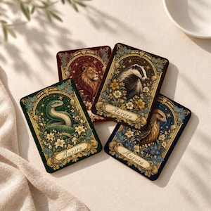 May include: Four rectangular cards featuring ornate gold borders and floral motifs. Each card displays a different animal: a green snake, a brown lion, a black and white badger, and a brown eagle. The word Aurora is printed on three cards.