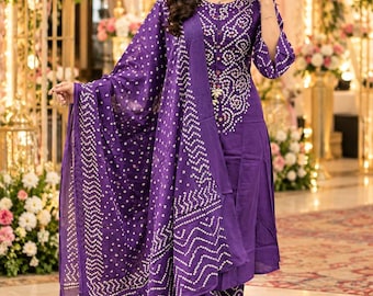 May include: A deep purple three-piece outfit consisting of a knee-length kurta with three-quarter sleeves, matching straight-leg trousers, and a long dupatta. The fabric features a white bandhani tie-dye pattern with geometric and circular motifs.