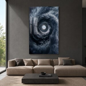 May include: A rectangular wall art print featuring a dark, swirling vortex of deep blue and charcoal gray clouds. The center of the spiral reveals a small, bright opening showing a patch of clear light blue sky, creating a high-contrast effect.