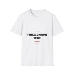 Puede incluir: Una camiseta blanca de manga corta con el texto "SIT BLAME" en letras rojas pequeñas, seguido del texto negro en negrita "FUNZIONAVA IERI" y una línea roja horizontal, con el pequeño texto rojo "not me" situado debajo de la línea.