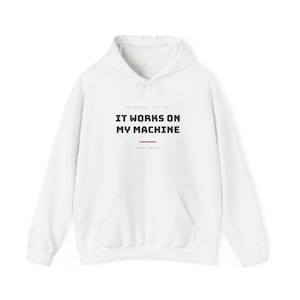 Op de afbeelding: Een witte hoodie met een kangoeroezak aan de voorzijde en lange mouwen. Op de borst staat de zwarte tekst IT WORKS ON MY MACHINE, met daarboven de kleinere tekst DEV SESSION EST. 2016 en daaronder works locally.