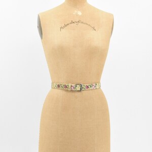 May include: A vintage floral patterned belt with a silver buckle on a dress form. The dress form is labeled "Palmenberg Cavanagh" and "Model 1953 12".