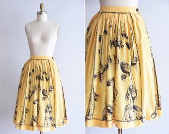 May include: A yellow midi skirt with a black and white sailboat print. The skirt has a pleated design and a button closure at the waist.