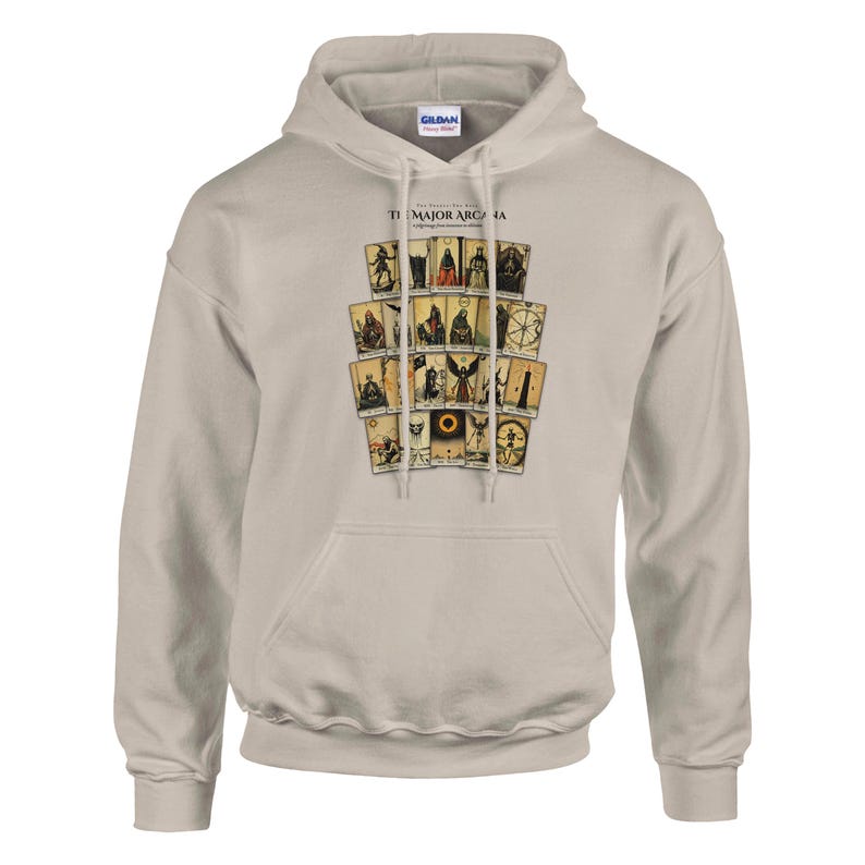 May include: A beige hooded sweatshirt featuring a graphic print of tarot cards arranged in a grid. The text "THE MAJOR ARCANA" is printed above the cards. The hoodie includes a front kangaroo pocket, long sleeves, and a drawstring hood.