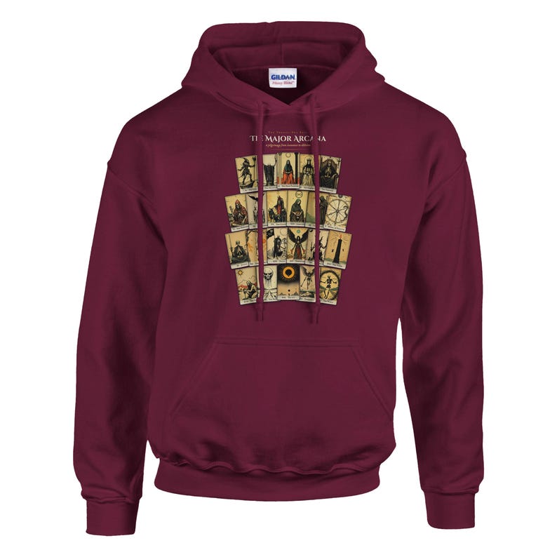 May include: A maroon hooded sweatshirt featuring a graphic print of twenty-two tarot cards arranged in a grid. The text "THE MAJOR ARCANA" is printed in white above the cards. The garment includes a front kangaroo pocket and matching drawstrings.