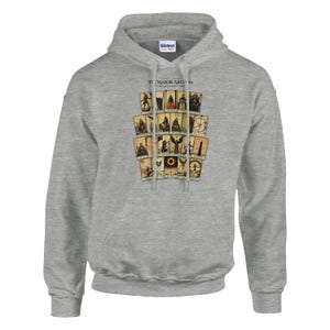 May include: A heather gray hooded sweatshirt featuring a graphic print of twenty-two tarot cards arranged in a grid. The text "THE MAJOR ARCANA" is printed in black above the cards. The hoodie includes a drawstring hood and a front kangaroo pocket.