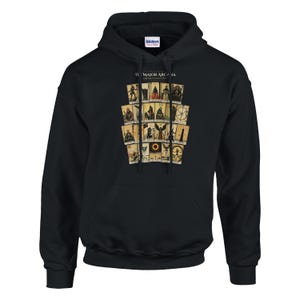May include: A black hooded sweatshirt featuring a graphic print of twenty-two tarot cards arranged in a grid. The text "THE MAJOR ARCANA" is printed in white above the cards. The hoodie includes a drawstring hood and a front kangaroo pocket.