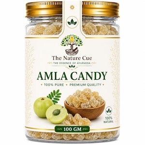 Könnte beinhalten: Ein durchsichtiges Glas mit goldenem Deckel, das 100 Gramm Amla-Bonbons enthält. Das Etikett zeigt den Text The Nature Cue, The Essence of Ayurveda, Amla Candy, 100% Pure, Premium Quality, 100 GM und 100% Natural sowie Bilder von Amla-Früchten.