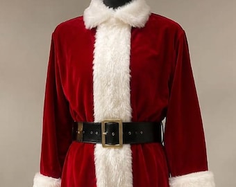 Puede incluir: Un disfraz de Papá Noel de terciopelo rojo que incluye una chaqueta de manga larga con ribetes de piel sintética blanca en el cuello, los puños y el dobladillo. La chaqueta se ajusta con un cinturón negro ancho con hebilla dorada. Pantalón de terciopelo rojo a juego y botas negras.