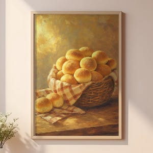 May include: A framed wall art print depicting a woven basket filled with golden-brown dinner rolls, resting on a wooden surface. The painting features a warm, glowing light and a checkered cloth liner, displayed in a room with shelves of bread.