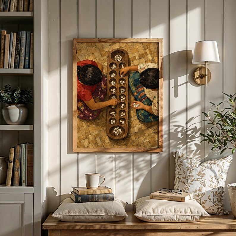 May include: A framed wall art print depicting two individuals playing a traditional mancala board game with small white shells. The artwork features a top-down view of the wooden board and the players, set against a textured woven mat background.