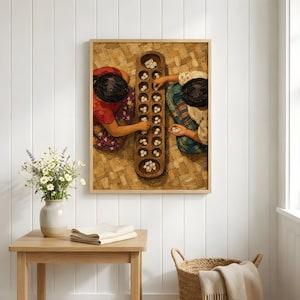 May include: A framed wall art print depicting two individuals playing a traditional mancala board game with cowrie shells on a woven mat. The artwork features warm earth tones, detailed textures of the game board, and patterned clothing.