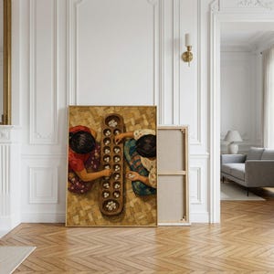 May include: A framed canvas print depicting two individuals from a top-down perspective playing a traditional board game with small white stones on a long, carved wooden board with multiple circular indentations, set on a woven mat surface.