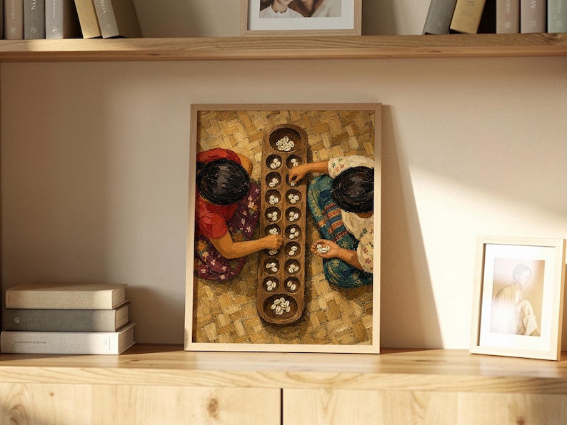 May include: A framed wall art print depicting two individuals playing a traditional mancala board game with small white shells. The wooden board features two rows of circular pits, and the scene is captured from a top-down perspective.