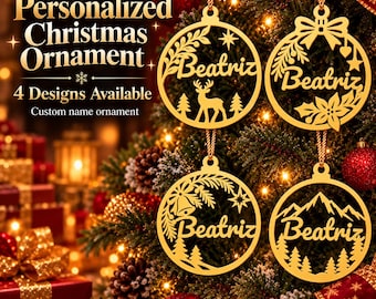 May include: Four gold-colored circular Christmas ornaments hanging on a tree, each featuring the name Beatriz in script. The designs include a deer, a bow with poinsettia, a bell with pine branches, and a mountain range with pine trees.