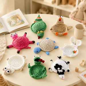 Peut inclure: Une collection de huit dessous de verre en crochet en forme d'animaux comprenant un cochon rose, une tortue verte avec un chapeau de fête, un poulet beige, une tortue bleue et beige, un lapin blanc avec une carotte, un mouton blanc, une grenouille verte et une vache noire et blanche.