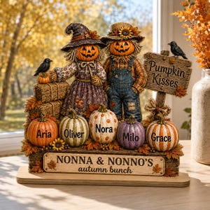 May include: A decorative autumn-themed tabletop display featuring two pumpkin-headed figures, one wearing a witch hat and the other a straw hat. Five pumpkins are personalized with the names Aria, Oliver, Nora, Milo, and Grace. A sign reads Pumpkin Kisses and Nonna & Nonno's autumn bunch.
