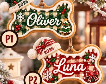 May include: Two bone-shaped Christmas ornaments with white icing edges. The top ornament features a green plaid pattern, the name Oliver, and a green hat with 2026. The bottom ornament features a red plaid pattern, the name Luna, and a red hat with 2026.