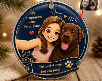 May include: A round, dark blue acrylic ornament featuring a cartoon illustration of a person and a brown dog. Text reads: My happines has four paws, Anna and Mila, and Not just a dog, but my heat. A small inset photo shows a person and a dog.