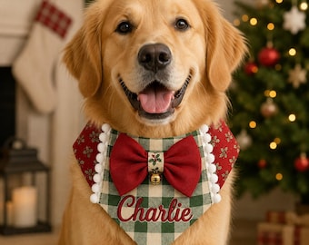 May include: A golden retriever wearing a festive pet bandana featuring a green and cream buffalo check pattern, a red bow, a small gold bell, and white pom-pom trim. The name Charlie is embroidered in red script on the front of the fabric.
