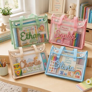 May include: Four rectangular, transparent mesh zipper pouches with fabric handles in light green, pink, beige, and light blue. Each pouch features a personalized name in matching yarn script: Ethan, Sophie, Charlie, and Olivia, containing educational books and art supplies.