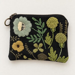 Può includere: Una pochette nera con cerniera caratterizzata da un intricato ricamo di vari elementi botanici, tra cui un grande fiore verde salvia, un fiore più piccolo color giallo senape e diversi steli frondosi e boccioli floreali rotondi.