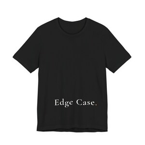 Puede incluir: Una camiseta negra de manga corta con cuello redondo. El texto "Edge Case." está impreso en una fuente serif blanca en la parte inferior central de la camiseta, con un pequeño punto naranja después de la palabra Case.