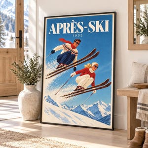 Könnte beinhalten: Ein gerahmtes vertikales Poster mit dem Titel APRÈS-SKI 1992, das eine Illustration im Vintage-Stil von zwei Skifahrern in Bewegung vor einem hellblauen Himmel und schneebedeckten Berggipfeln zeigt. Die Skifahrer tragen bunte Winterkleidung.