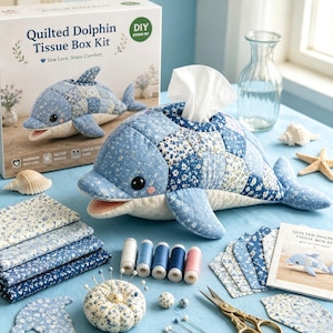 Peut inclure: Un kit de bricolage pour boîte à mouchoirs en forme de dauphin matelassé, comprenant une housse en tissu à motifs floraux bleus et blancs. Le kit contient des carrés de tissu, cinq bobines de fil, un pelote à épingles, des aiguilles et un livret.