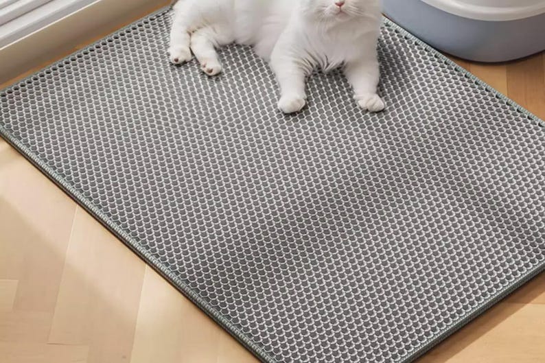 Waterproof Cat Litter Mat featuring a double-layer honeycomb structure for trapping scattered litter and cat sand. Non-slip backing keeps the mat securely in place while protecting hardwood, tile, laminate, and carpet flooring. Soft, paw-friendly EVA material offers comfort and durability. Ideal litter box accessory for indoor cats, multi-cat households, and pet owners seeking an easy-clean litter trapping solution.
