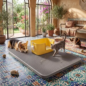 May include: A rectangular grey cat litter mat with a honeycomb texture surface, featuring a bright yellow plastic litter box with a matching scoop attached to the side. The mat is designed to catch litter particles and sits on a tiled floor.